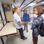 Hannes Baumann, left, assistant professor of marine sciences, speaks with Turner Cabaniss, marine and waterfront operations manager, and Zophia Baumann, assistant research professor of marine sciences, in the expanded wet laboratory space aboard the R/V Connecticut. The upgrades to the vessel included doubling the laboratory space on board. (Peter Morenus/UConn Photo)