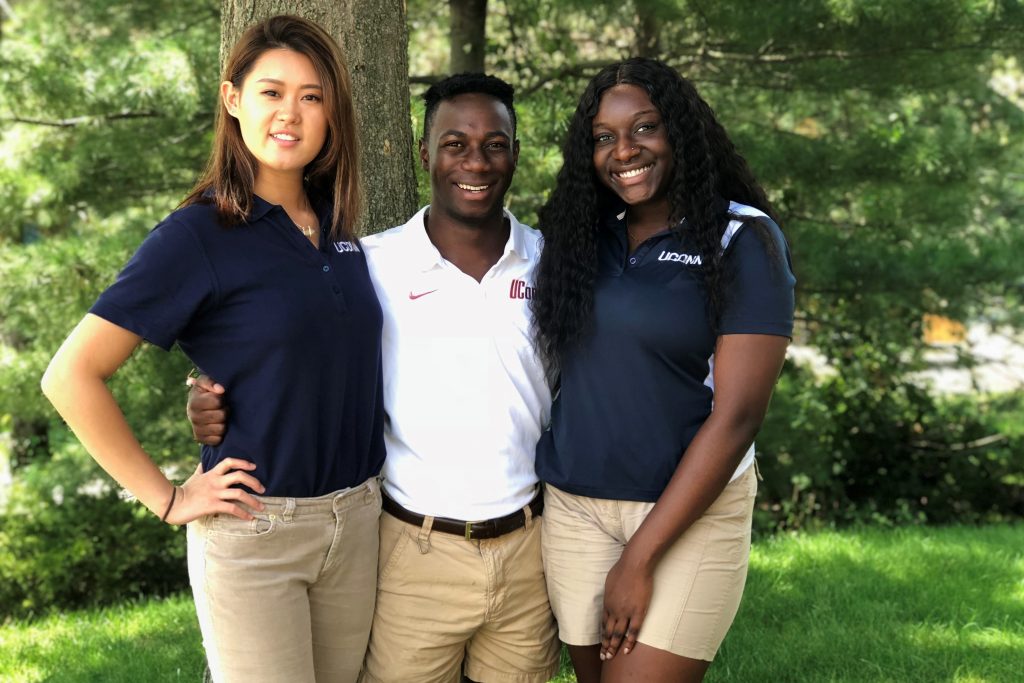 Kailin Lu '20 (CLAS), left, Emmanuel 'Manny' Chinyumba '20 (CLAS), and Princess Madu '19 (CLAS), tour guides at the Lodewick Visitors Center, are among the students talking about what they are looking forward to this year at UConn. (Julie Bartucca/UConn Photo)