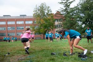 Members of Fine Arts House (wearing pink) and Public Health House (in blue) play Sneaker Scramble. (Defining Studios Photography for UConn)