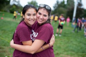 Two friends from Engineering House embrace during Learning Communities Field Day. (Defining Studios Photography for UConn)