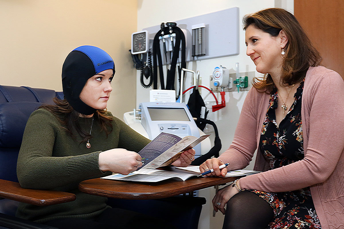 Molly Tsipouras, right, breast oncology nurse navigator, with a patient in the Carole and Ray Neag Comprehensive Cancer Center. (Stan Godlewski for UConn Health)
