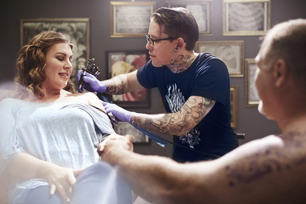Tattoo artist tattooing woman's shoulder. (Getty Images)