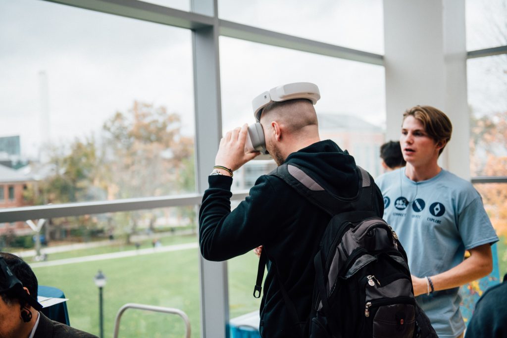 A student wearing a virtual reality headset watches live drone footage from a pilot flying a drone outside the Student Union during the Innovation Expo on Oct. 29. (Nathan Oldham/UConn Photo)