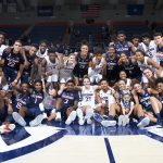 The UConn Men's and Women's Basketball Teams pose for a group shot, together with the two youngsters (front row) from Team IMPACT whom the teams have 'adopted.' (Stephen Slade '89 (SFA) for UConn)