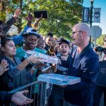 In preparation for First Night, Men's Basketball head coach Dan Hurley distributes pizza to fans waiting in line outside Gampel Pavilion. (Jason Reider/UConn Athletics Photo)