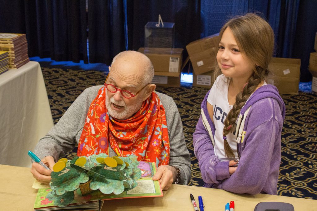 Renowned children’s book author Tomie dePaola signs Quinn Ostergren’s copy of his popup book 'Brava, Strega Nona!' (Lucas Voghell '20 (CLAS)/UConn Photo)