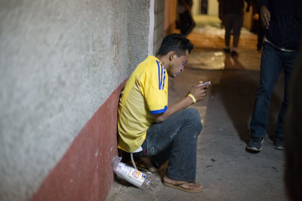 In Mexicali, Mexico, a migrant uses his cellphone. (Photo by Luis Boza/VIEWPress/Corbis via Getty Images)