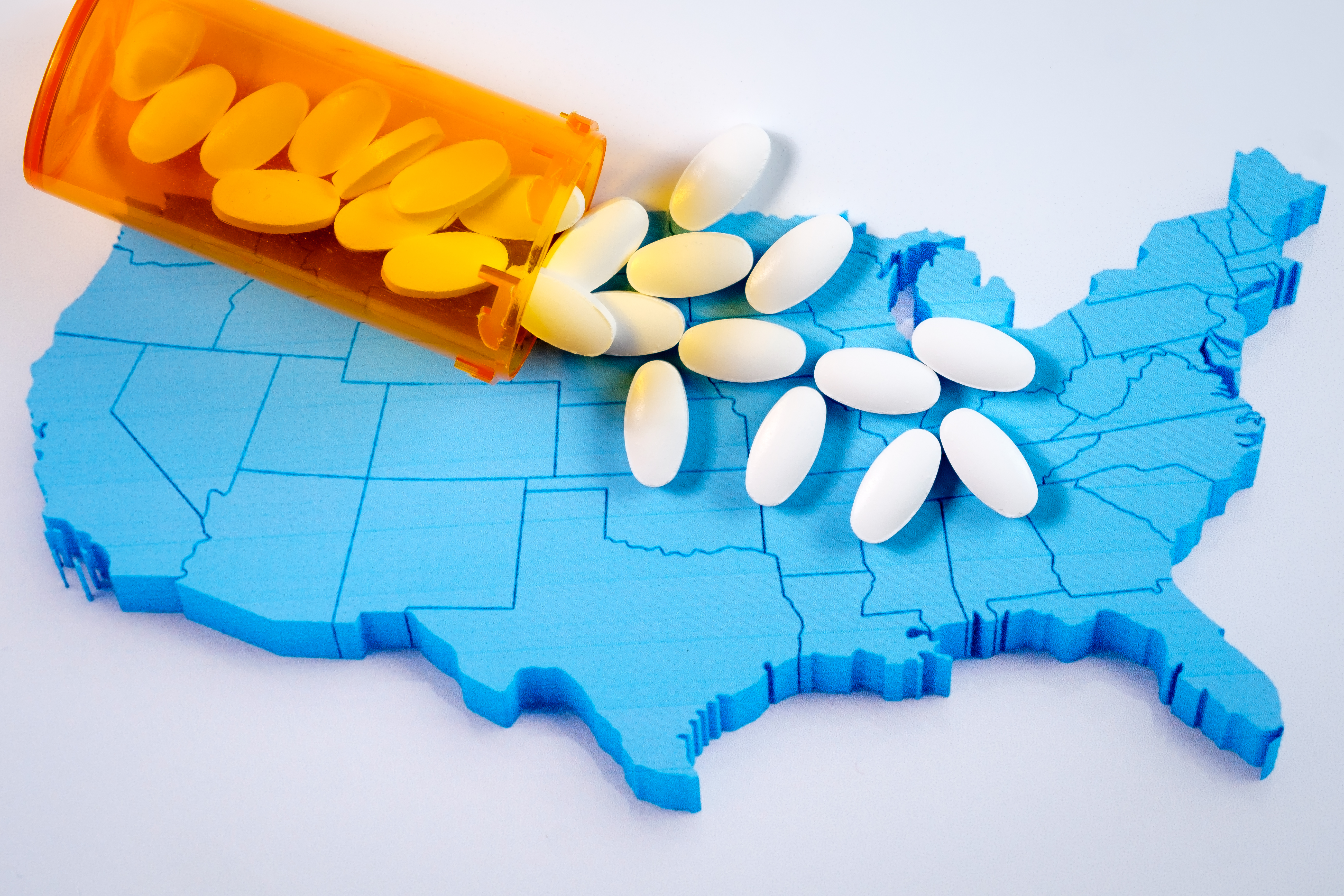 White pharmaceutical pills spilling from prescription bottle over American map. (Stuart Richie/iStock/Getty Images)