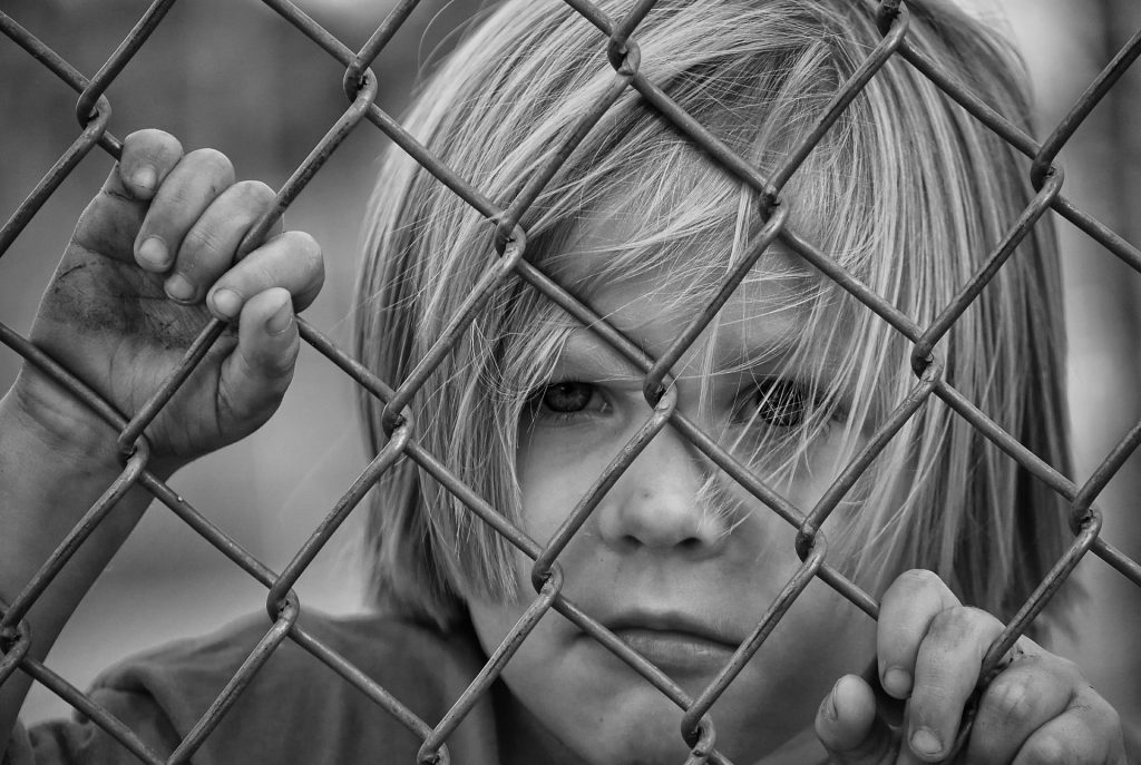 Boy looking through fence