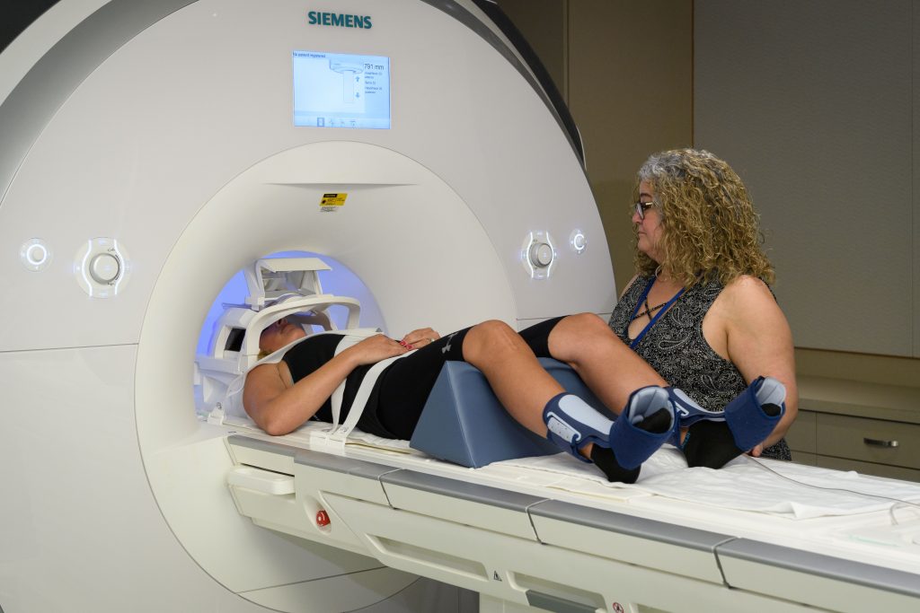 MRI service manager Elisa Medeiros prepares a patient for functional MRI testing at the BIRC in the Phillips Communication Sciences Building. (Peter Morenus/UConn Photo)