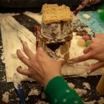 A gingerbread creation takes shape in the hands of a team from the First Year Experience program. (Lucas Voghell ’20 (CLAS)/UConn Photo)