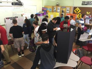 Students at Manchester High School review a set of human rights “museum” exhibits they created as part of an Early College Experience course in human rights taught by alum Jacob Skrzypiec ’13 (ED), ’14 MA. (Photo courtesy of Jacob Skrzypiec)