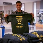 This year's Kwanzaa celebration was one of many events marking the 50th anniversary of the African American Cultural Center. Here, Mekhi Amos ’21 (BUS) holds up an anniversary t-shirt outside the Student Union Ballroom. (Lucas Voghell ’20 (CLAS)/UConn Photo)