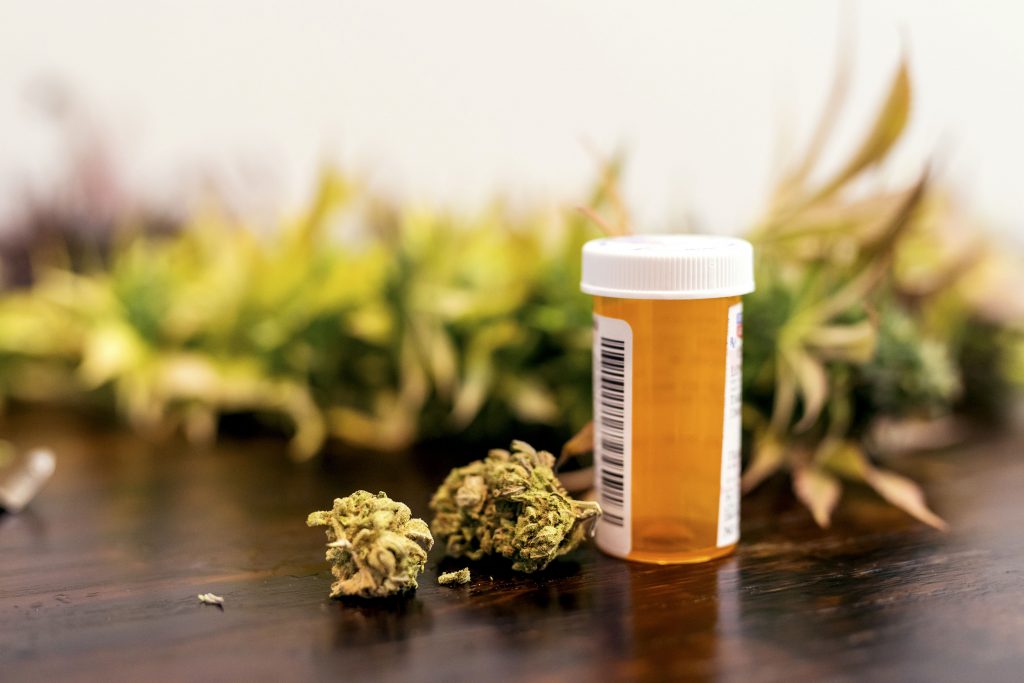 Marijuana buds sitting next to prescription medicine bottle. (Getty Images)