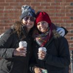 Friendship and hot coffee help keep out the cold for these students, pictured outside the Student Union. (Sean Flynn/UConn Photo)