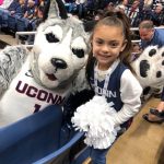 Daniela poses for a photo with the Husky mascot.