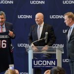 Thomas Katsouleas, left, holds up a basketball jersey presented by board chair Thomas Kruger, center, and Gov. Ned Lamont at a press conference following his appointment to be the 16th president of the University on Feb. 5, 2019. (Peter Morenus/UConn Photo)