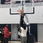Mamadou Diarra helps Rylan reach the basket on the practice court at the Werth Family Basketball Champions Center, as Eric Cobb looks on, and Alterique Gilbert, far left, snaps a photo. (UConn Men's Basketball Photo)
