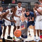Rylan demonstrates his ball handling skills to members of the Men's Basketball team, at First Night, on Oct. 12, 2018. (Stephen Slade '89 (SFA) for UConn)