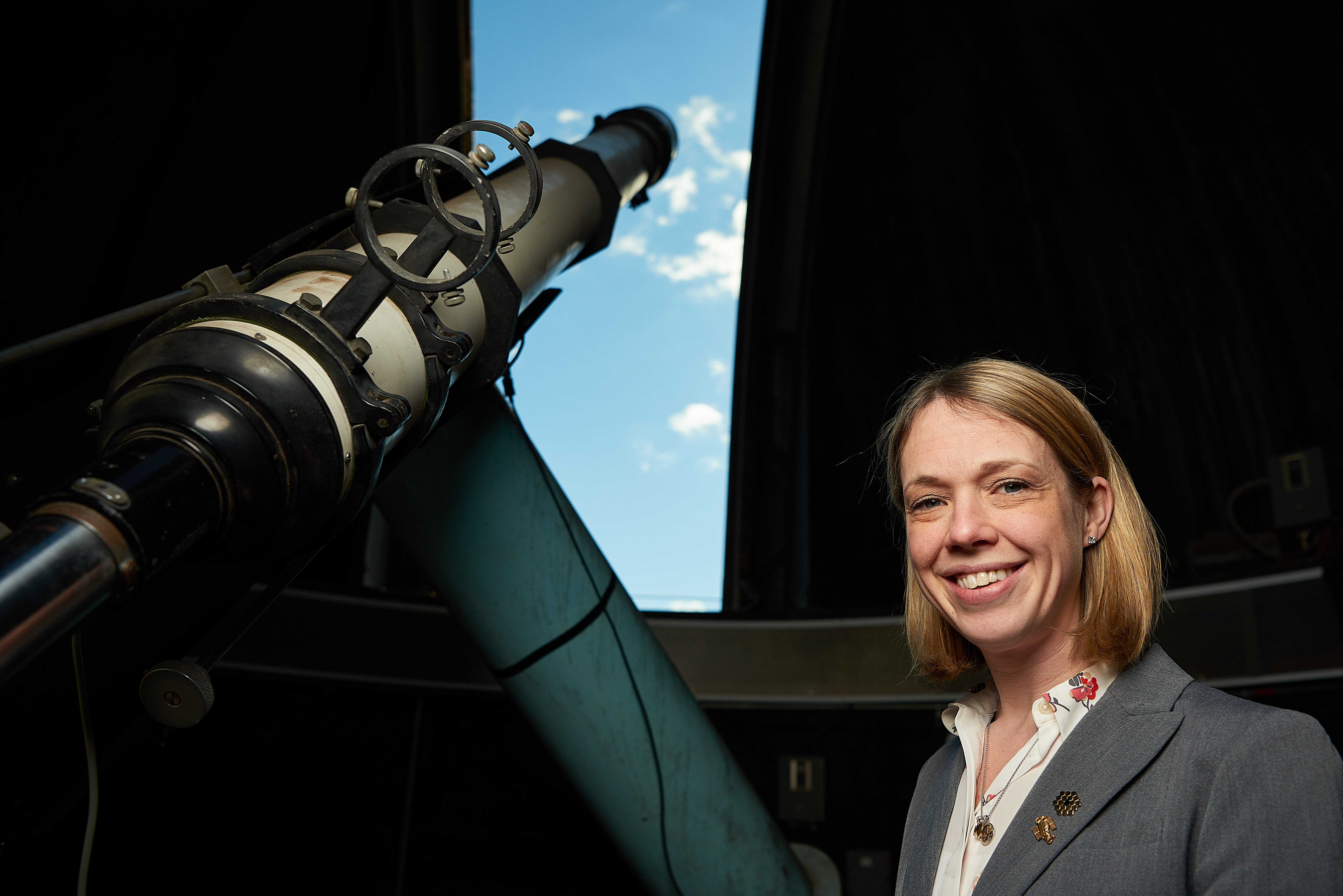 Kate Whitaker, assistant professor of physics, stands next to a telescope inside the observatory on top of the Gant Complex on Feb. 14, 2019. (Peter Morenus/UConn Photo)