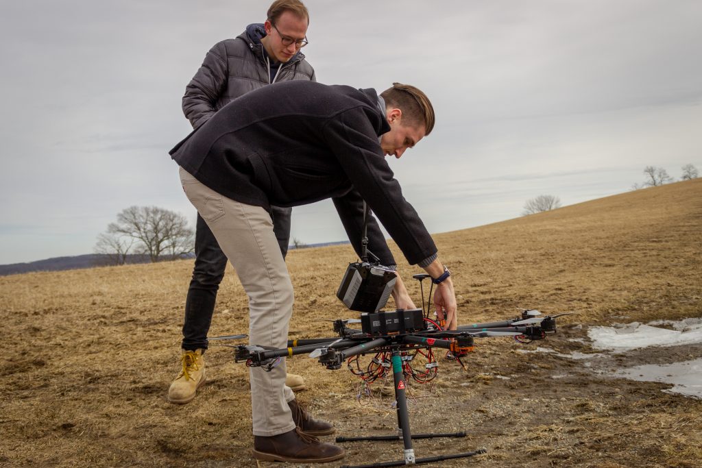 Ryan Heilemann '19 (foreground) and Josh Steil '19 check their drone before a recent flight test. (Christopher Larosa/UConn Photo)
