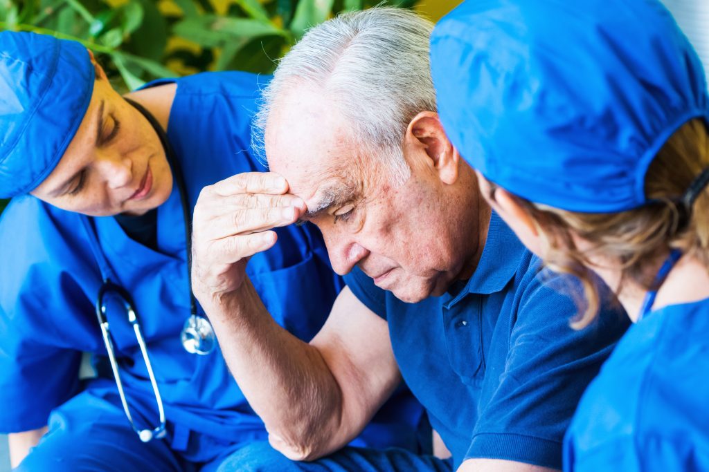 Nurses examining an ill senior patient. (Getty Images)