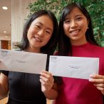 Medical students Katherine Tian, left, Katelyn Wong show off the envelopes before opening them at the residency Match Day ceremony held in the Academic Atrium at UConn Health in Farmington on March 15, 2019. (Peter Morenus/UConn Photo)