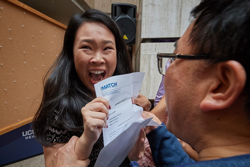 Julianna Lau reacts as she opens the envelope containing her residency assignment during the medical student residency match day ceremony held in the Academic Atrium at UConn Health in Farmington on March 15, 2019. (Peter Morenus/UConn Photo)