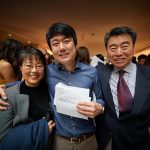 Kyle Shin, center, with his parents Eun-Ju Shin, right, visiting professor of literature, cultures and languages and Dong-Kuk Shin, professor of computer science and engineering, following the residency match day ceremony held in the Academic Atrium at UConn Health in Farmington on March 15, 2019. (Peter Morenus/UConn Photo)