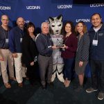 Staff of Veterans Affairs and Military Programs pose with Jonathan the Husky and their team award, after the Spirit Awards ceremony. (Peter Morenus/UConn Photo)