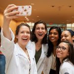 Julia Lafen, left, and other second year dental students pose for a selfie at the UConn Health academic atrium after their white coat ceremony. (Peter Morenus/UConn Photo)