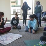 Lynne Nicole Smith ’96, left, speaks with Xena Hodgdon ’22 (ACES), left, and Daviel Garcia ’22 (ACES), seated, and Aishat Alatise ’20 (ACES), left, and Tonya Gray ’20 (CLAS), standing, about the relationship of Yin (earth and body) and Yang (heaven and spirit) to one's Qi (mind and life). (Sean Flynn/UConn Photo)