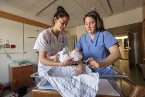 Rachel Calabro ’19 (NUR), left, assists Courtney Tobin RN ’13 in Labor and Delivery during Tobin's internship at UConn Health on March 6, 2019. (Sean Flynn/UConn Photo)