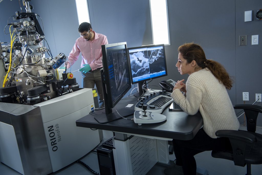 Nicholas May and Bahar Ahmadi work with the ZEISS Orion NanoFab Helium Ion Microscope. (Al Ferreira/UConn Photo)