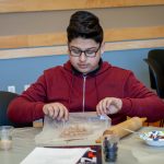 Mohammad Saeed from Two Rivers Magnet Middle School in East Hartford makes his own 'asphalt cookies' with a variety of ingredients. (Christopher LaRosa/UConn Photo)