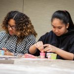 Ariyah Powers, left, and Dabria Arana from West Side STEM Magnet Middle School in Groton, Connecticut, use strawberries to learn how to extract DNA. (Christopher LaRosa/UConn Photo)
