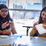 Dhanya Chasmawala, left, and Julia Alkhayer from Timothy Edwards Middle School in South Windsor, Connecticut, use simple materials to learn about Newton’s Law of Motion. (Christopher LaRosa/UConn Photo)