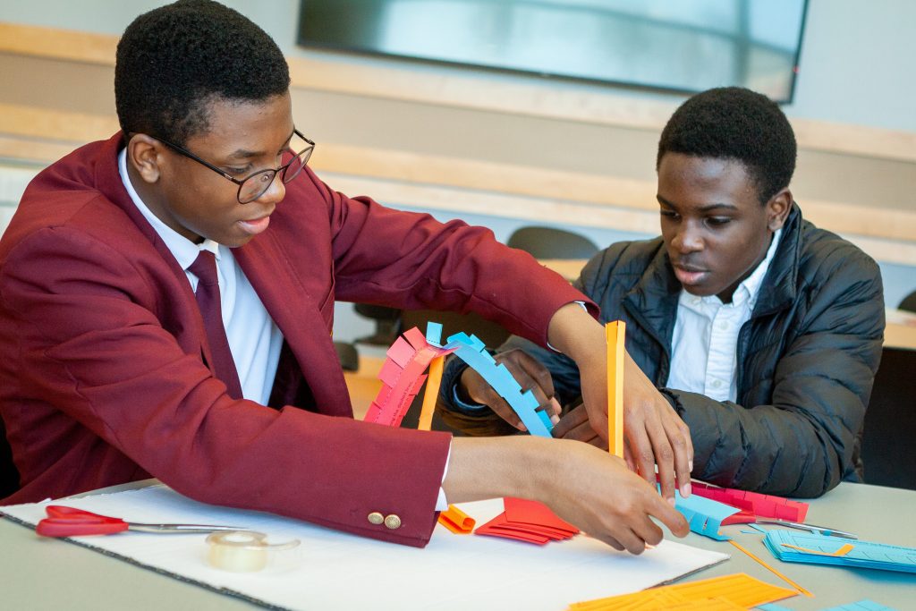Devonte Daley, left, and Keenon Christian from Jumoke Academy in Hartford learn about Newton’s Laws of Motion by building and testing a balloon-powered rocket car from simple materials. (Christopher LaRosa/UConn Photo)