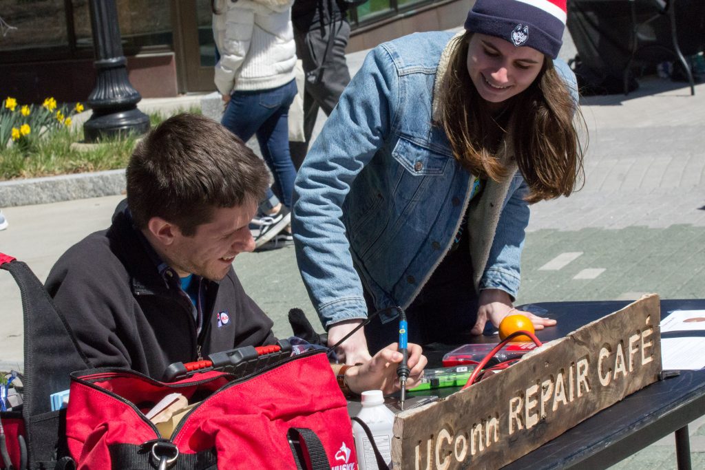 Ryan Cortier, a recent engineering grad, left, and Sophie MacDonald ’20 (ENG) promote the concept of a new club, where students could bring anything from furniture to iPhones and learn to fix it themselves. The new club would be called the UConn Repair Café. (Lucas Voghell ’20 (CLAS)/UConn Photo)