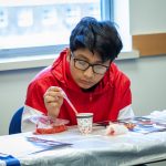 Isai Cevallos from Pulaski Middle School in New Britain learns how to extract DNA from strawberries to learn more about biomedical engineering. (Christopher LaRosa/UConn Photo)