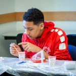 Elijah Black from West Side Middle School in Groton learns about biomedical engineering by learning the procedures to extract DNA from strawberries. (Christopher LaRosa/UConn Photo)