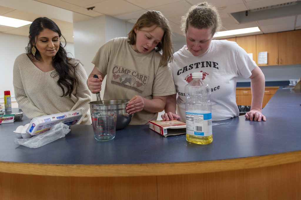 From left, Saira Khurana ’19 (CLAS) assists Katie and Kate while making cupcakes in Sprague Residence Hall. (Sean Flynn/UConn Photo)