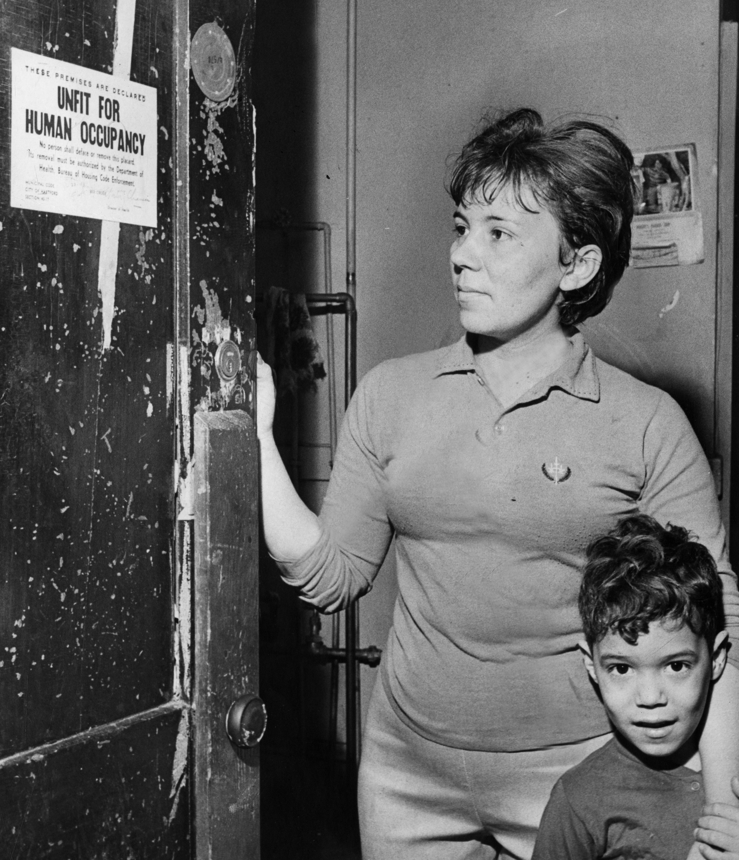 A tenant examines the distressing notification that her building is 'unfit for human occupancy,' on Feb. 2, 1970. The building was owned by Jerome Diamond, who was cited for numerous housing code violations and was issued warrants to appear in housing court.