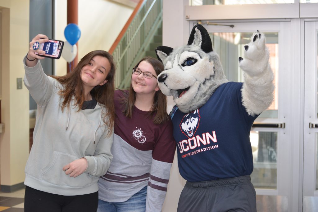 Students take a selfie with Jonathan the Husky at the Gentry Building during UConn’s Giving Day this spring. (Shawn Kornegay/Neag School)