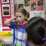 Sawyer Montstream, 8, shows how her invention can help kids keep their sweatbands on. (Lucas Voghell ’20 (CLAS)/UConn Photo)