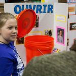 Payton Farrell, 8, shows off her device 'Ouvrir,' which can help people open buckets that have their lids on too tight. (Lucas Voghell ’20 (CLAS)/UConn Photo)