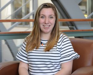 Kaitlyn Ferrara sitting in a chair in the Gentry Building. 