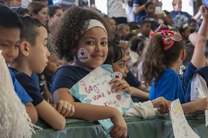 Second-grader Juliet Cruz, facing the camera, is among the students of Kennelly School in Hartford, celebrating UConn Day along with her schoolmates, teachers, and UConn School of Education students on May 2, 2019. (Sean Flynn/UConn Photo)
