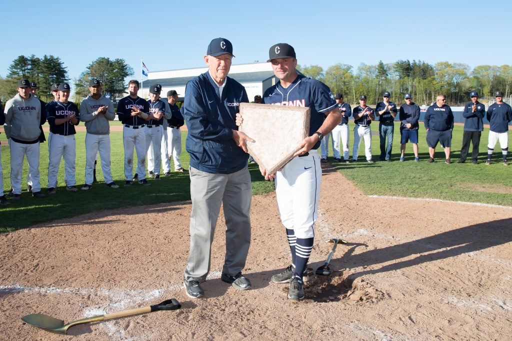 Jim Penders, right, accepts the home plate from Andy Baylock. (Stephen Slade/UConn Today)