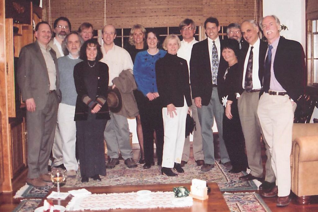 Group photo of 15, mostly UConn Health researchers, in a living room